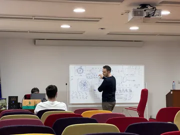 A mentor at the whiteboard, close to midnight